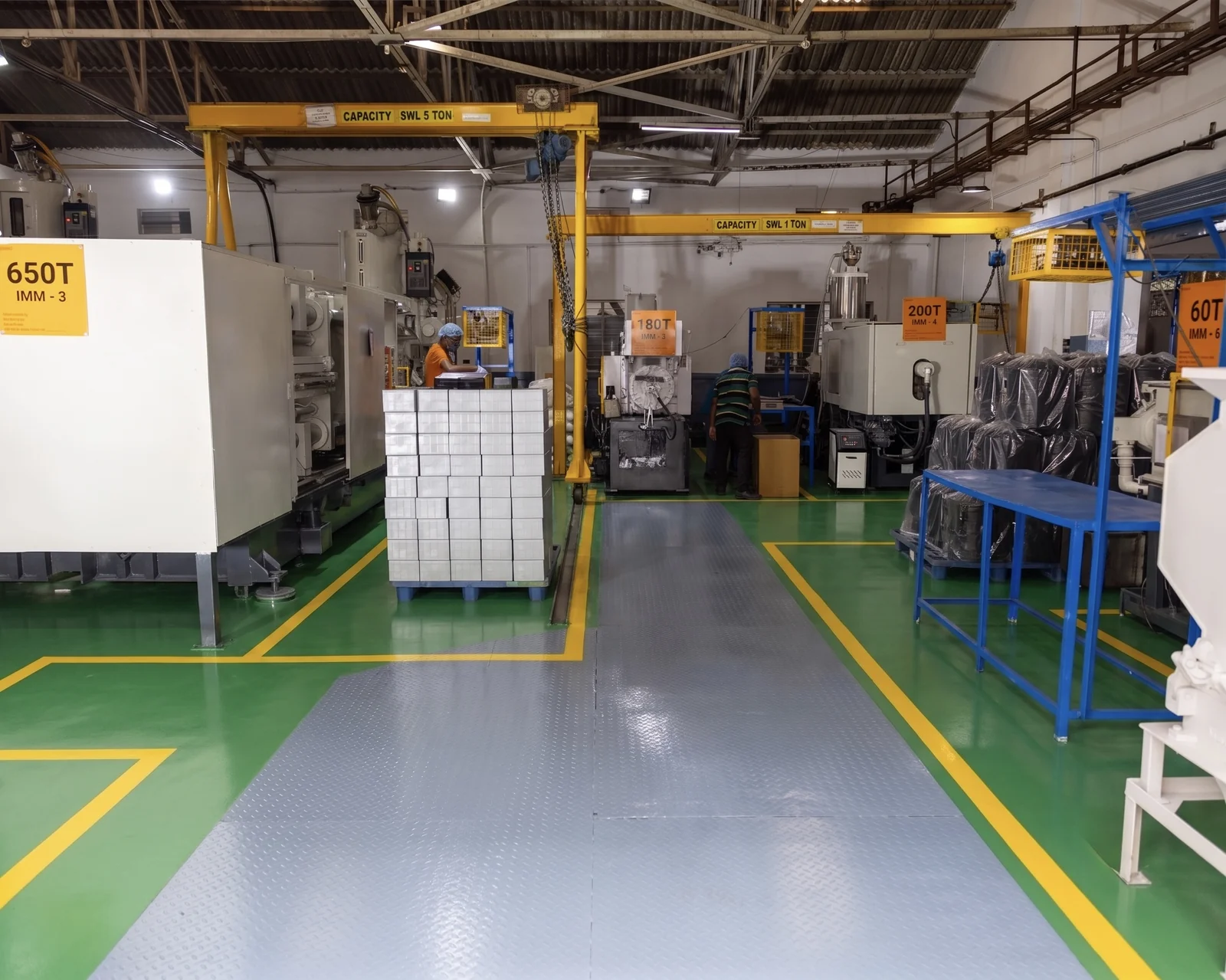 Kruger Industries injection moulding shop floor in Bengaluru — machines from 60 to 1300 tonnes under overhead cranes